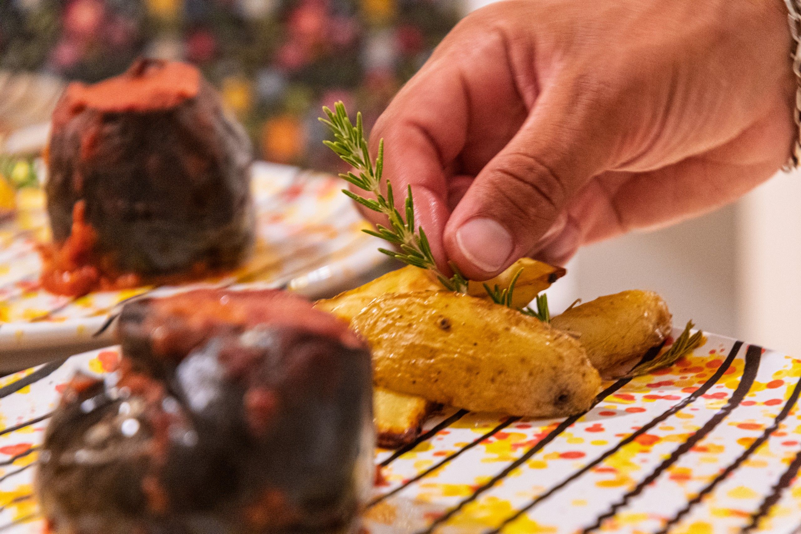 mano cameriere metre mette il rosmarino sulle patate al forno durante la cena allo Shanti Home Restaurant B&B Bed and Breakfast a due passi dal mare a Vieste immerso nella natura nel Gargano in Puglia