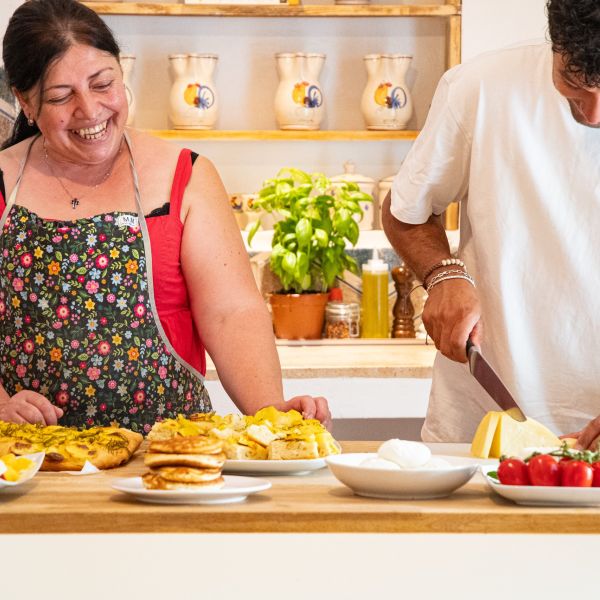 cuoca mentre cucina i prodotti tipici con cameriere del B&B Bed and Breakfast Shanti Home Restaurant a due passi dal mare a Vieste immerso nella natura nel Gargano in Puglia