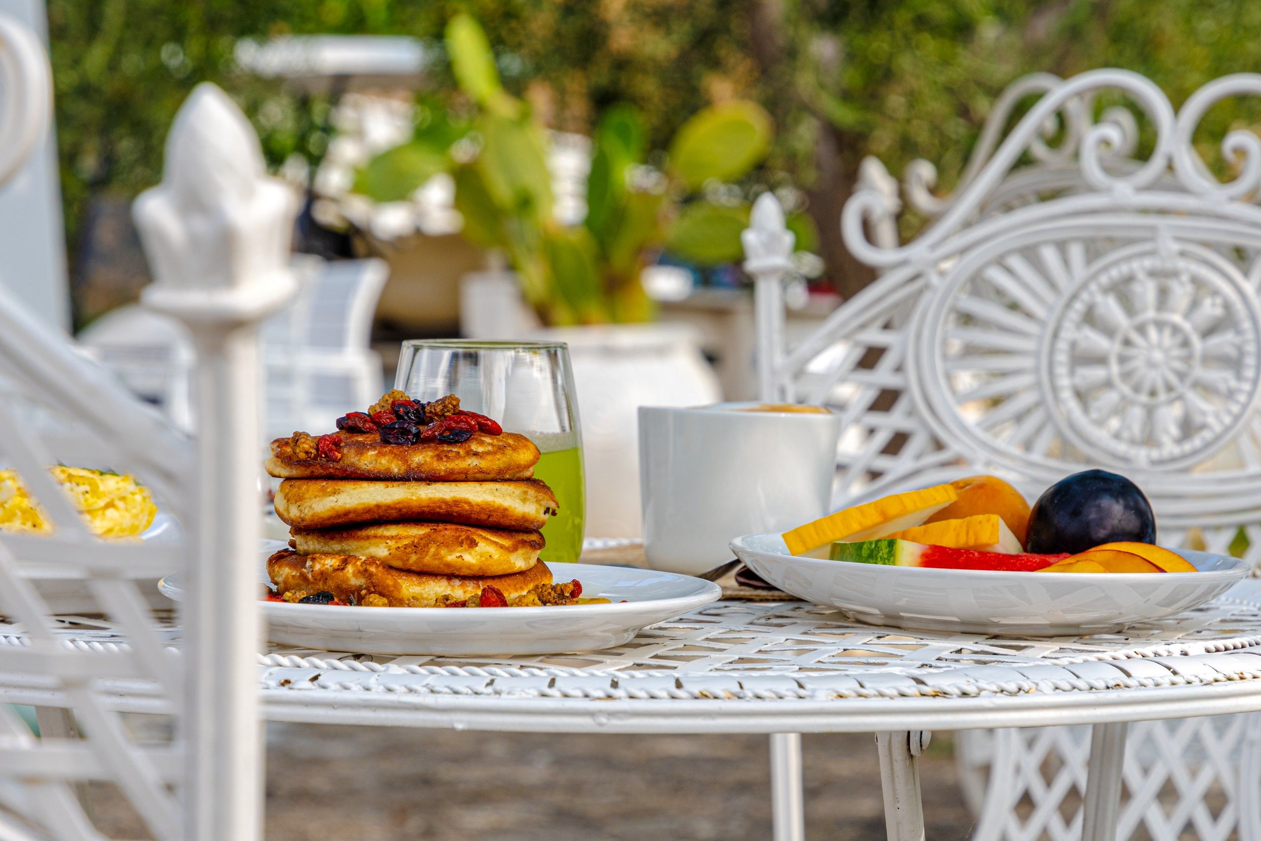 tavolo giardino con panecake e frutta fresca durante la colazione del B&B Bed and Breakfast Shanti Home Restaurant a due passi dal mare a Vieste immerso nella natura nel Gargano in Puglia